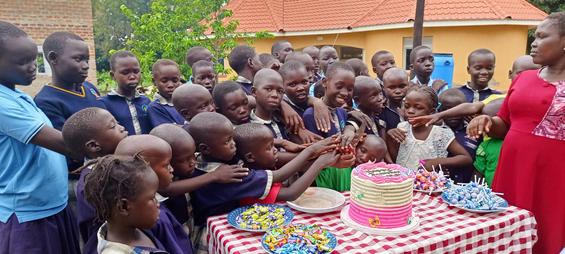 Children of Biyaya Child Development Centre gathered together, smiling, at a celebration in Adjumani, Uganda